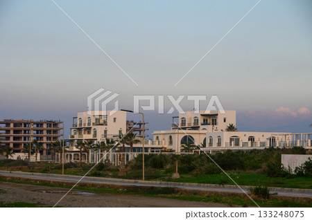 Modern architecture meets coastal serenity in a developing seaside community at dusk 133248075