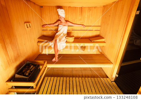 woman sitting relaxed in wooden sauna woman sitting relaxed in wooden sauna 133248108