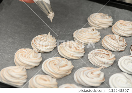 Whipping up sweet delights with meringue cookies in a cozy kitchen Whipping up sweet delights with meringue cookies in a cozy kitchen 133248207