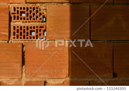 Intricate patterns in a warm-toned brick wall revealing craftsmanship and texture in a construction site Intricate patterns in a warm-toned brick wall revealing craftsmanship and texture in a construction site 133248303