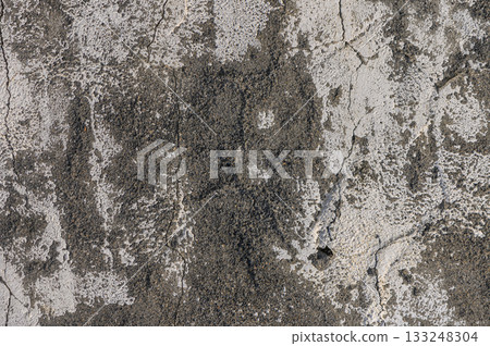 Weathered concrete surface reveals intriguing textures and patterns over time in an urban environment 133248304