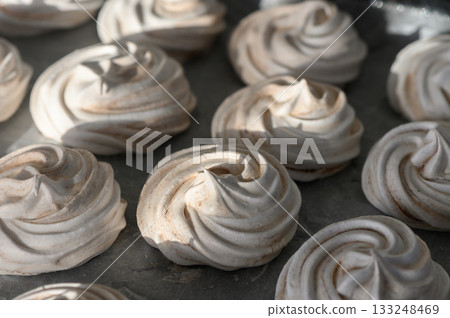 Delicious meringues with a glossy finish tempt dessert lovers in a cozy kitchen setting Delicious meringues with a glossy finish tempt dessert lovers in a cozy kitchen setting 133248469