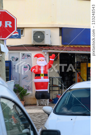 Inflatable Santa greets visitors outside a bustling store during the festive season Inflatable Santa greets visitors outside a bustling store during the festive season 133248543