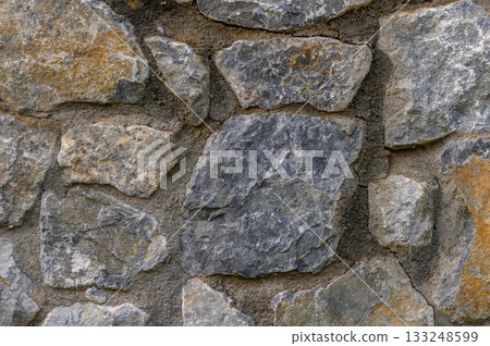 Natural textures of a rustic stone wall showcasing diverse rock shapes and hues 133248599
