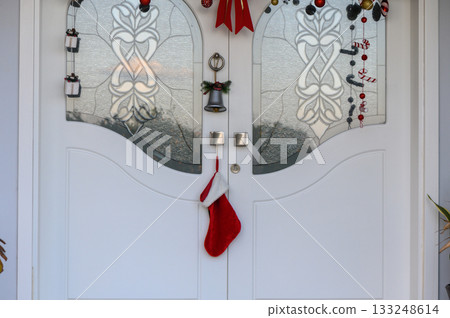Festive holiday decorations adorn the entrance of a welcoming home during the joyful winter season Festive holiday decorations adorn the entrance of a welcoming home during the joyful winter season 133248614