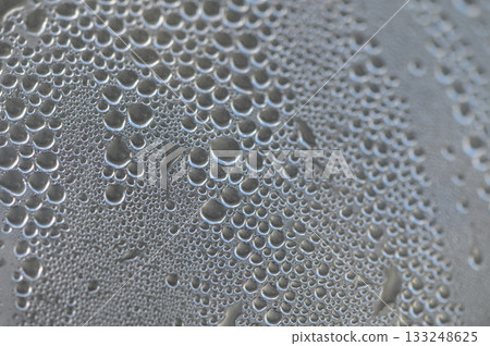 Droplets of water gracefully cling to a surface after a rain shower, capturing the light beautifully Droplets of water gracefully cling to a surface after a rain shower, capturing the light beautifully 133248625