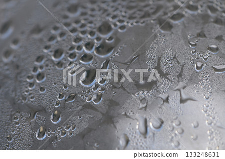 Droplets of water glisten on a metallic surface after a refreshing rain shower at dawn Droplets of water glisten on a metallic surface after a refreshing rain shower at dawn 133248631