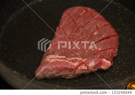 Sizzling steak being seared to perfection in a hot skillet at a cozy kitchen setting 133248849