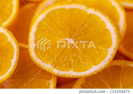 Sun-kissed orange slices arranged artfully on a vibrant surface Sun-kissed orange slices arranged artfully on a vibrant surface 133248875