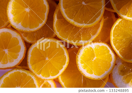 Freshly sliced lemons arranged beautifully on a vibrant surface for a sunny kitchen vibe 133248895