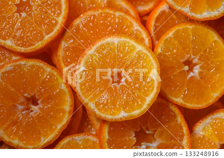 Bright and vibrant mandarin slices arranged beautifully in a stunning display of freshness 133248916