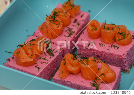 Delightful salmon mousse served on colorful plates at a vibrant summer gathering 133248945
