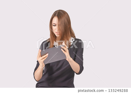 Caucasian young adult female using tablet in black dress with lace collar Caucasian young adult female using tablet in black dress with lace collar 133249288