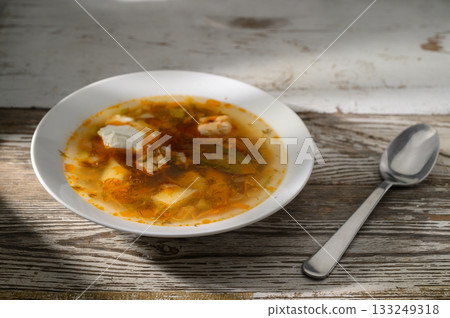Warm soup bursting with flavors served in a rustic bowl on a wooden table Warm soup bursting with flavors served in a rustic bowl on a wooden table 133249318