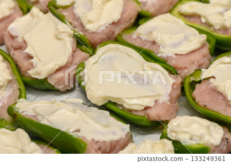 Savory stuffed bell peppers filled with creamy mixture prepared in a cozy kitchen setting 133249361