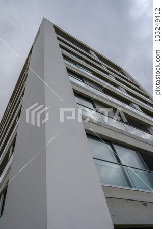 Modern architectural marvel reaches for the cloudy sky in an urban setting 133249412