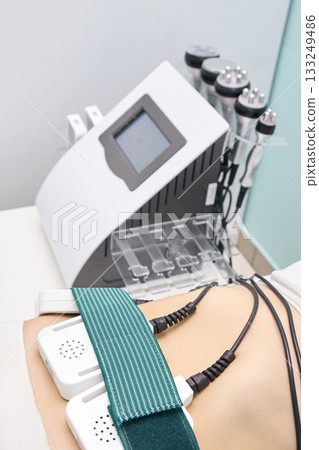 Female undergoing non-invasive body contouring treatment with advanced medical 133249486