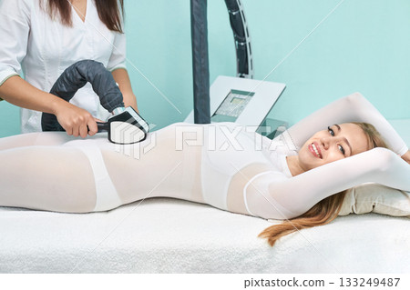 Asian female receiving cryolipolysis treatment at spa center for body contouring 133249487