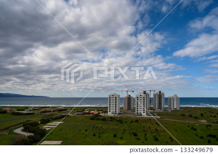 Coastal development under dramatic skies along the serene beach landscape 133249679