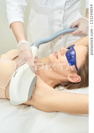 Young caucasian female undergoing laser hair removal treatment on armpit 133249854