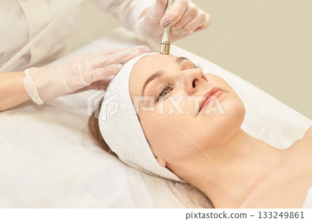 Caucasian female receiving anti-aging microdermabrasion facial treatment at spa Caucasian female receiving anti-aging microdermabrasion facial treatment at spa 133249861