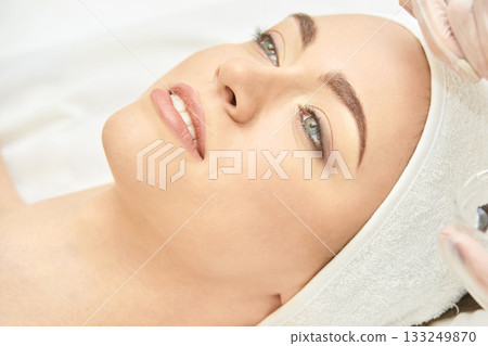 Caucasian female enjoying relaxing facial treatment at spa with skincare Caucasian female enjoying relaxing facial treatment at spa with skincare 133249870