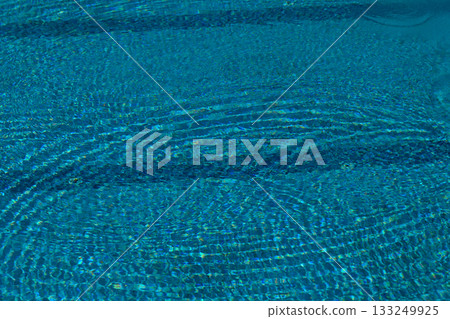 Rippling turquoise water captures sunlight in a serene summer afternoon oasis Rippling turquoise water captures sunlight in a serene summer afternoon oasis 133249925