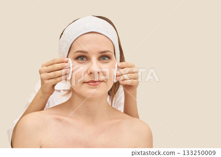 Caucasian female adult receiving facial treatment at spa with relaxed 133250009