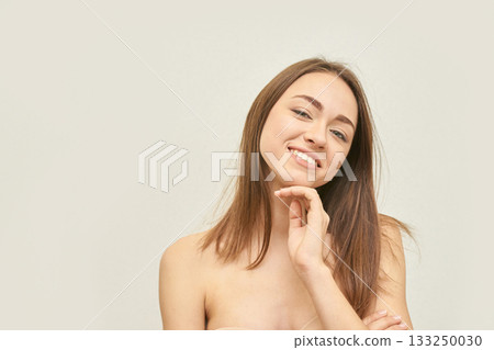 Smiling young caucasian female with brown hair posing confidently against 133250030