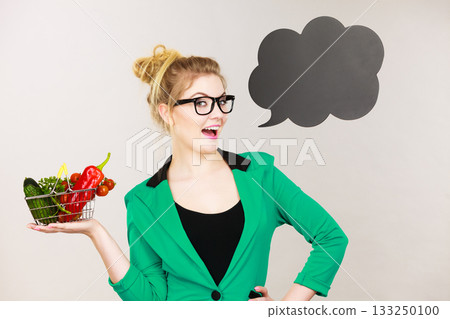 Businesswoman having vegetables holding shopping basket Businesswoman having vegetables holding shopping basket 133250100