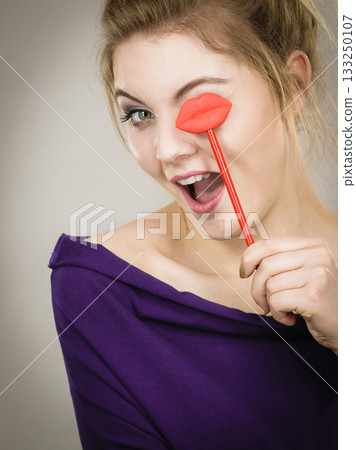 Happy woman holding lips on stick Happy woman holding lips on stick 133250107