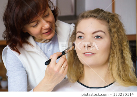 Woman getting make up done by artist Woman getting make up done by artist 133250114