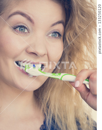 Woman brushing cleaning teeth 133250120