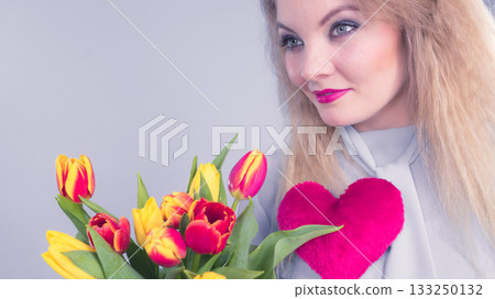 Woman holds tulips and red heart Woman holds tulips and red heart 133250132