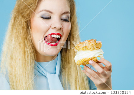 Funny woman holds cream puff cake 133250134