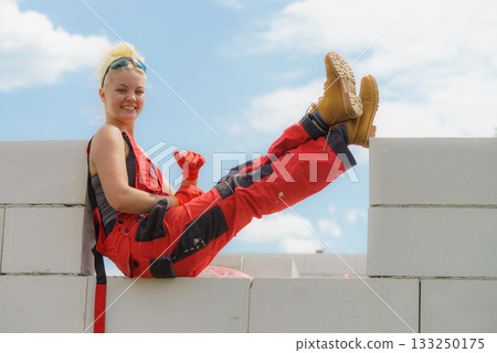Woman taking break on construction site Woman taking break on construction site 133250175