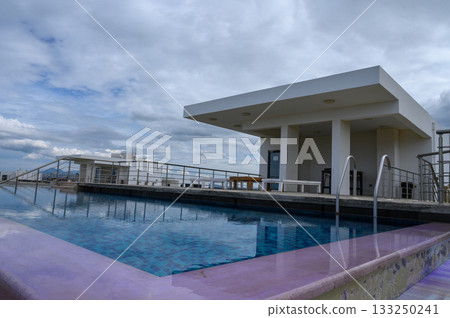 Rooftop poolside retreat with serene views and soft clouds at twilight Rooftop poolside retreat with serene views and soft clouds at twilight 133250241