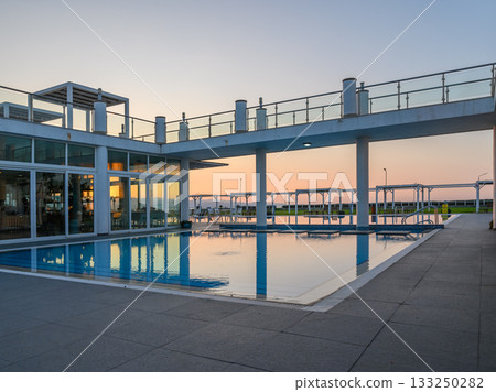 Relaxing sunset by the tranquil poolside at a coastal retreat in the evening Relaxing sunset by the tranquil poolside at a coastal retreat in the evening 133250282