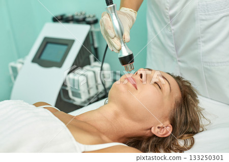 Female receiving facial treatment in spa, asian adult woman relaxing, skincare 133250301