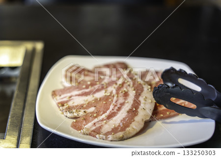 在烤肉店烤五花肉 133250303