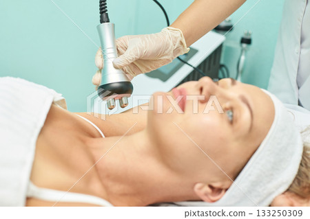 Caucasian female receiving facial treatment with cavitation machine in spa Caucasian female receiving facial treatment with cavitation machine in spa 133250309