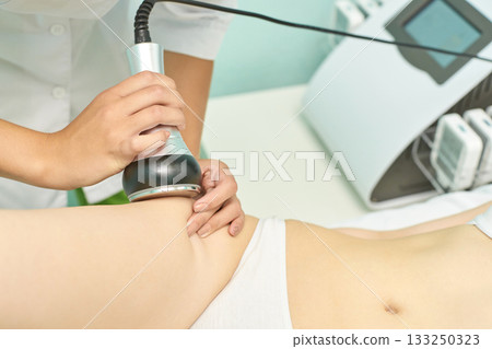 Caucasian female undergoing non-invasive ultrasonic cavitation treatment Caucasian female undergoing non-invasive ultrasonic cavitation treatment 133250323