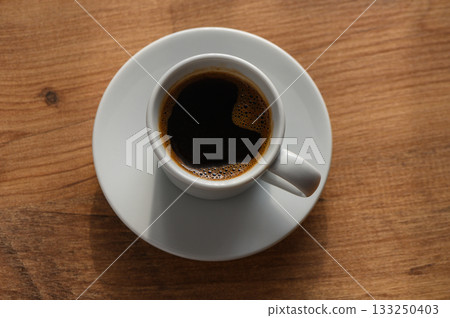 A serene coffee break at home with a steaming cup on a rustic wooden table A serene coffee break at home with a steaming cup on a rustic wooden table 133250403