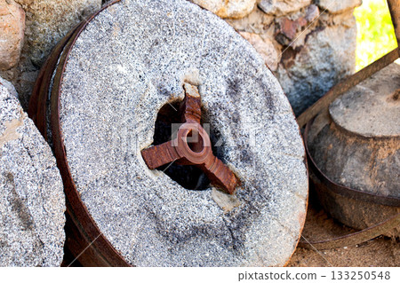 Old, used stone millstones from a mill used to grind grain into flour, museum exhibits Old, used stone millstones from a mill used to grind grain into flour, museum exhibits 133250548