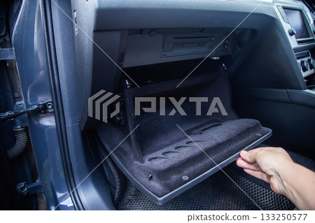 Replacement of a modern new anti-allergenic and antibacterial cabin filter in a car, close-up Replacement of a modern new anti-allergenic and antibacterial cabin filter in a car, close-up 133250577