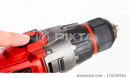 Switch in a modern screwdriver on a drill, close-up. White background, isolate, industry Switch in a modern screwdriver on a drill, close-up. White background, isolate, industry 133250581