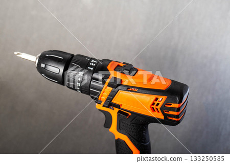 High-performance cordless drill on a gray background for home improvement tasks High-performance cordless drill on a gray background for home improvement tasks 133250585