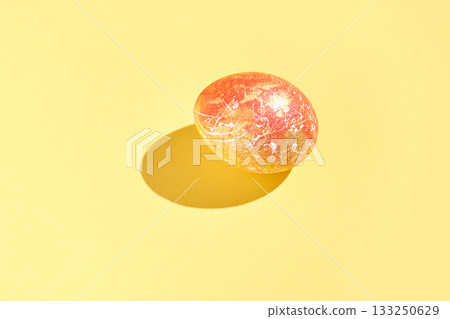 Single colorful easter egg on vibrant yellow background with decorative 133250629