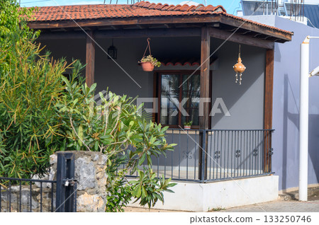 Charming traditional house with lush greenery in a quiet neighborhood on a sunny day 133250746