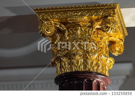 A richly detailed gold-leaf Corinthian capital with acanthus leaves and ornate scrolls 133250850